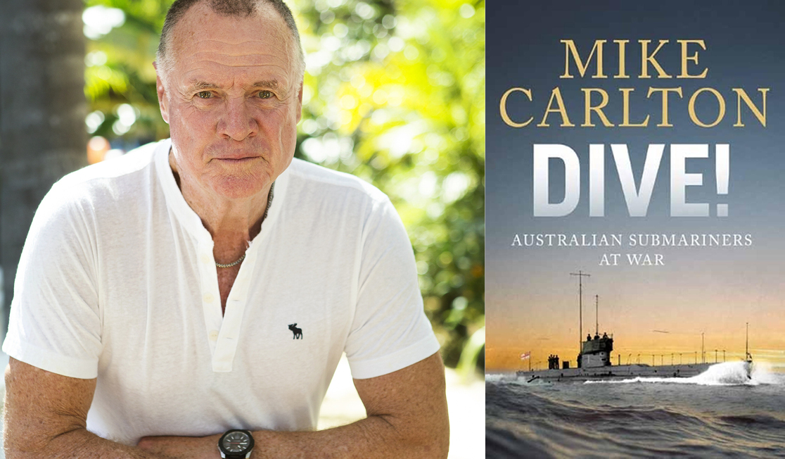 Mike is wearing a white polo shirt, he has very short grey hair and is looking at the camera