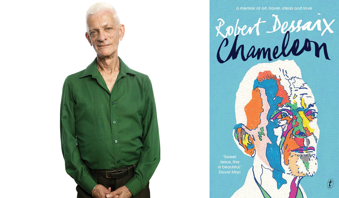 Robert wears a dark green shirt, he has short white hair and is looking at the camera