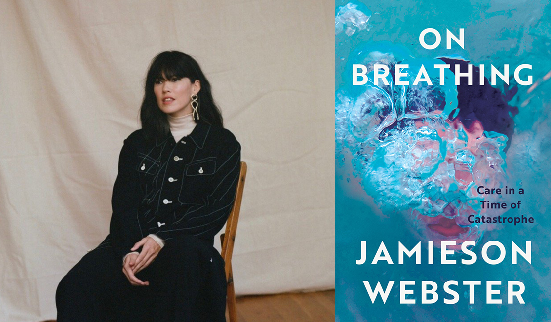 Jamieson Webster sits on a wooden chair in front of a white background. Jamieson has long dark hair and a fringe and gold earrings. Jamieson wears a dark jacket and skirt.