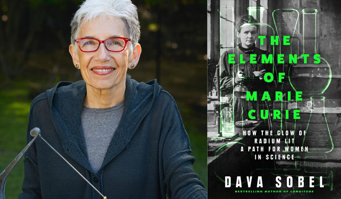 Dava Sobel wears a dark jacket and red framed glasses. Dava has short grey hair and is smiling.