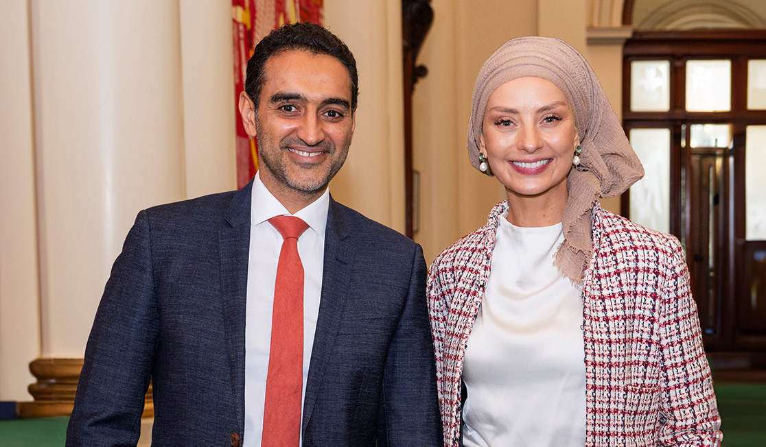 Waleed Aly and Susan Carland pose smiling to camera.