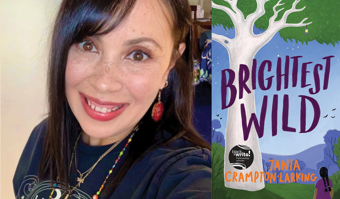 Tania Crampton-Larking wears a dark top and necklaces. Tania has red earrings on and brown hair with a fringe. Tania is smiling.