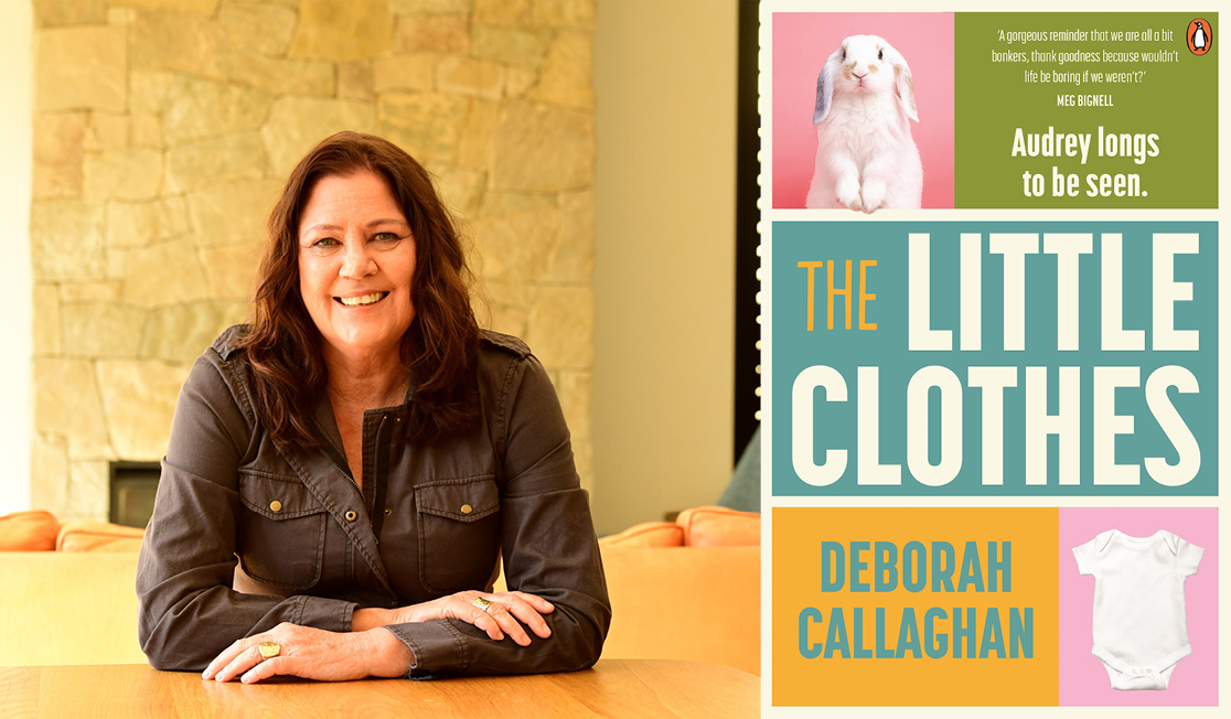 Deborah wears a dark gray shirt, has mid length dark brown hair and has a brick wall behind it