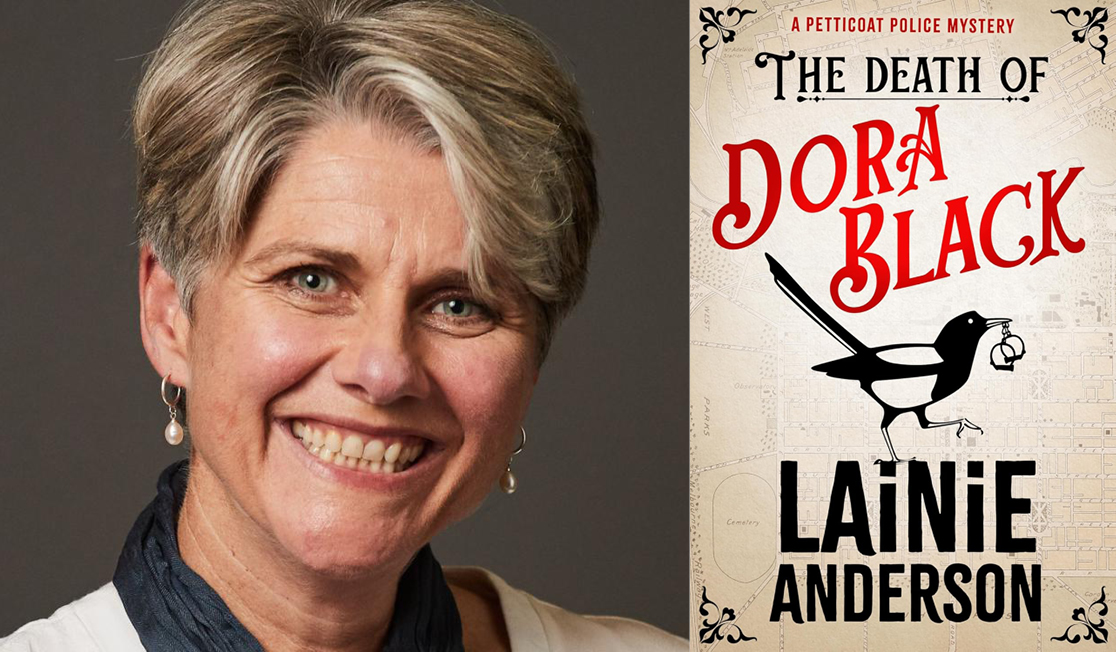 Lainie Anderson stands in front of a grey background wearing a white top and earrings. Lainie has short grey hair and is smiling.