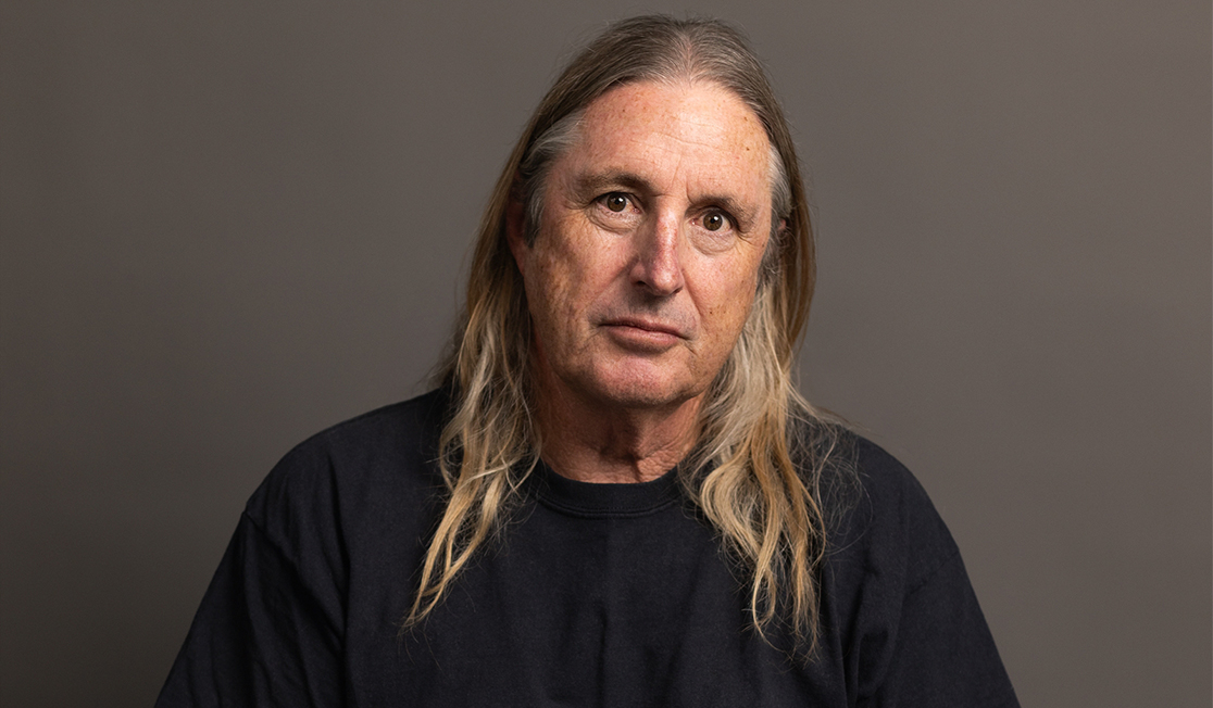 Australian author Tim Winton has long hair just below his shoulders and a black jumper